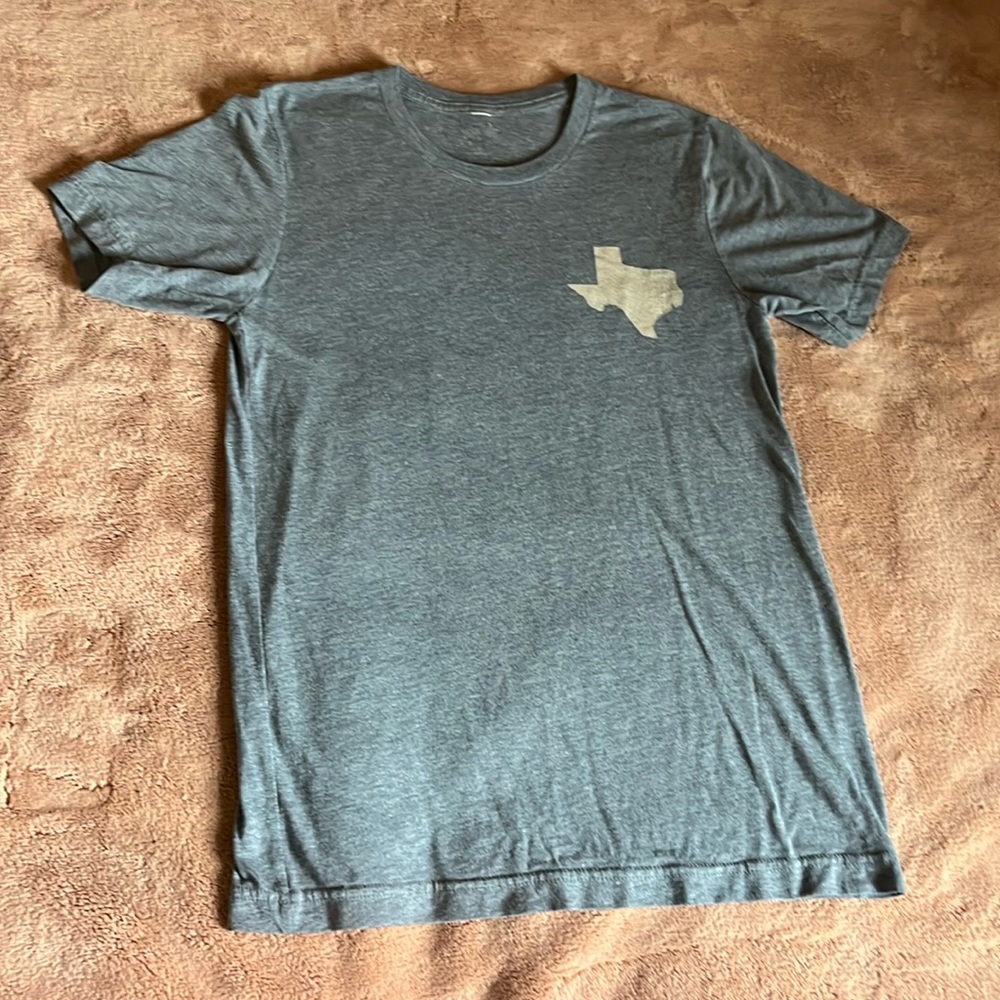“Texas State Symbol*” “TX lettering” (ON BACK) W/Camo Print. Size Medium.